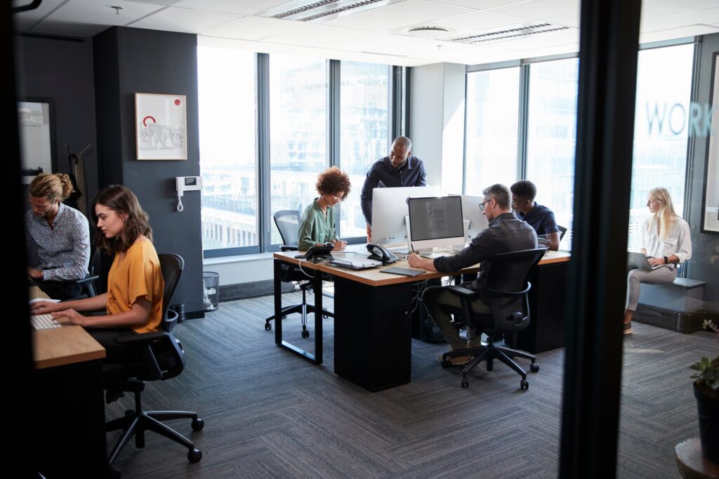 young-creative-team-working-together-at-computers-in-a-casual-office-seen-from-doorway.jpg
